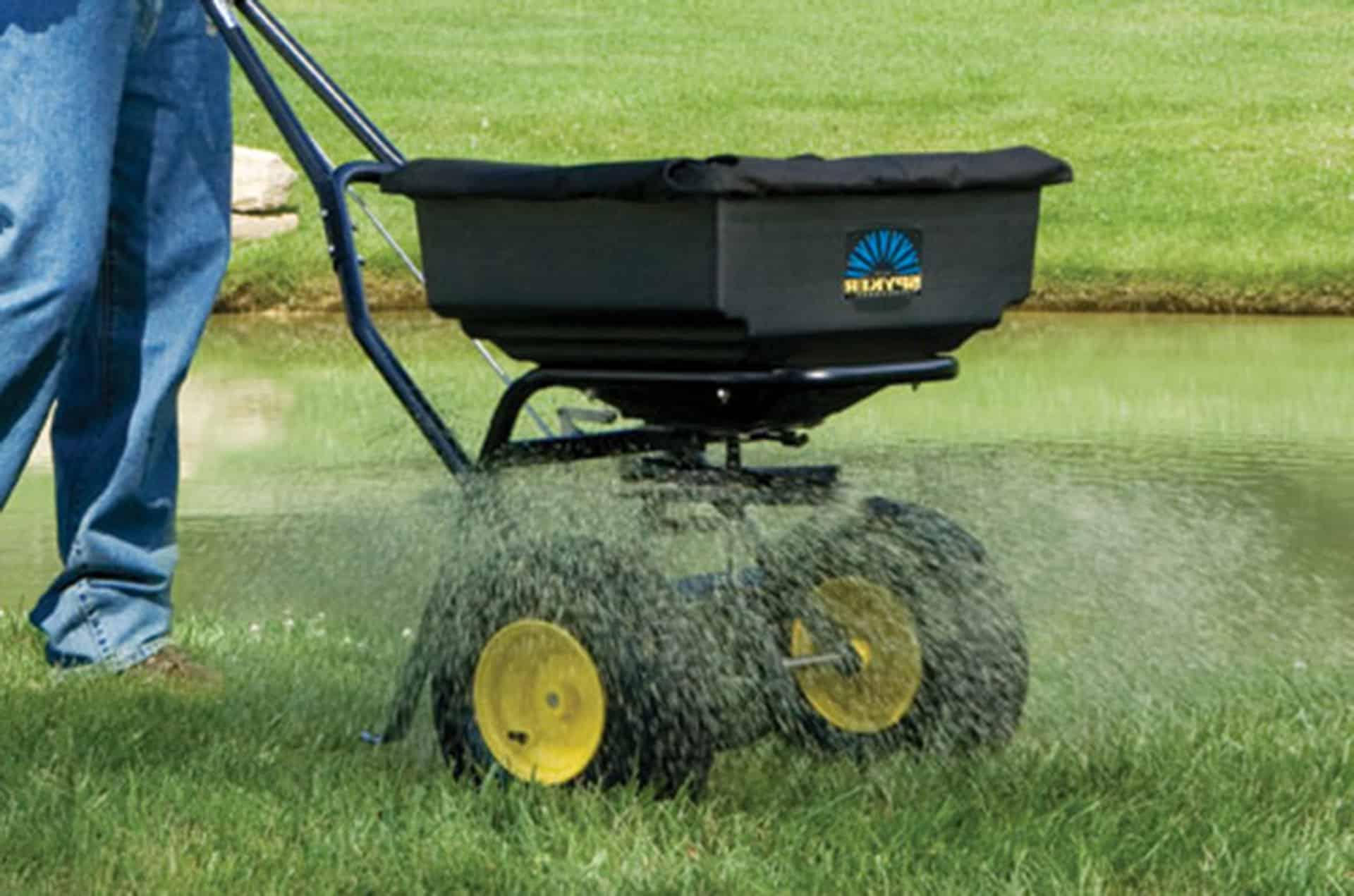 Man pushing seed spreader